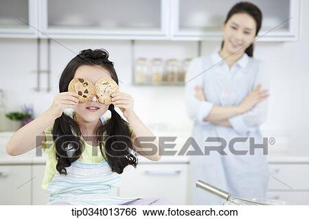 Stock Photograph - a kid playing with cookies in the kitchen. Fotosearch