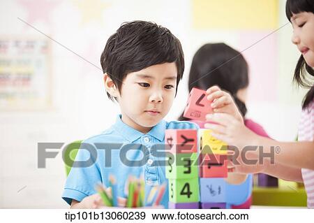 a kid playing with toy cubes on a table View Large Photo Image Stock Photo - a kid playing with toy cubes on a table. Fotosearch