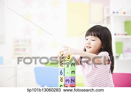 Stock Image - a kid playing with toy cubes. Fotosearch