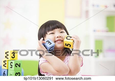 Stock Image - a kid playing with toy cubes. Fotosearch