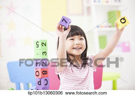 Stock Photograph - a kid playing with toy cubes. Fotosearch