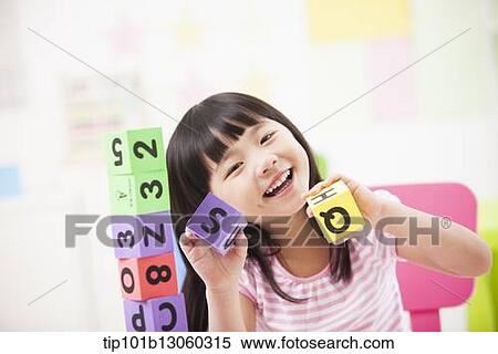 Stock Photography - a kid playing with toy cubes. Fotosearch