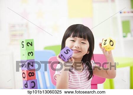 Stock Photography - a kid playing with toy cubes. Fotosearch