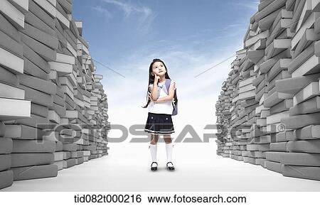 a kid with school bag standing between piles of books View Large Photo Image Stock Photograph - a kid with school bag standing between piles of books. Fotosearch