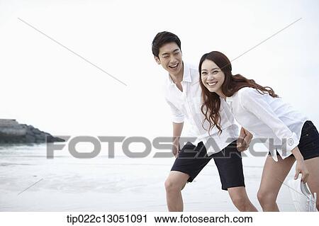 Stock Image - a man and a woman at a beach. Fotosearch