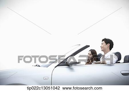 Stock Image - a man and a woman in a convertible car. Fotosearch
