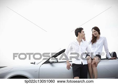 Stock Image - a man and a woman in a convertible car. Fotosearch