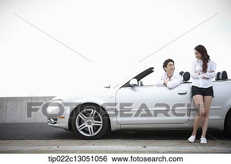 Stock Photograph - a man and a woman in a convertible car. Fotosearch
