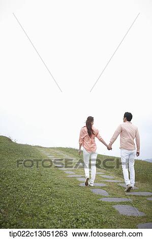 a man and a woman on a road on a grass field View Large Photo Image Stock Image - a man and a woman on a road on a grass field. Fotosearch