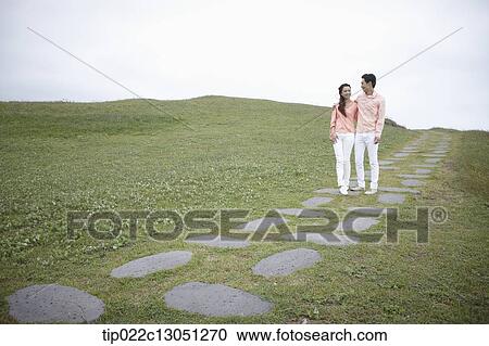 a man and a woman on a road on a grass field View Large Photo Image Stock Image - a man and a woman on a road on a grass field. Fotosearch