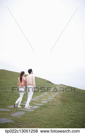 a man and a woman on a road on a grass field View Large Photo Image Stock Photo - a man and a woman on a road on a grass field. Fotosearch