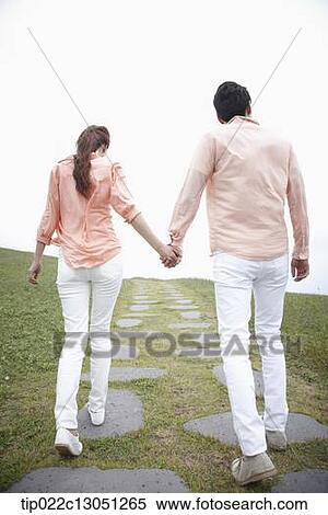 a man and a woman on a road on a grass field View Large Photo Image Stock Photography - a man and a woman on a road on a grass field. Fotosearch