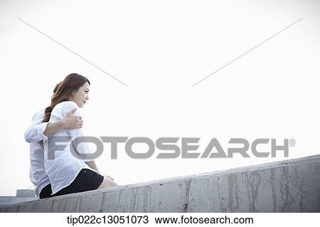 a man and a woman sitting on an edge View Large Photo Image Stock Image - a man and a woman sitting on an edge. Fotosearch