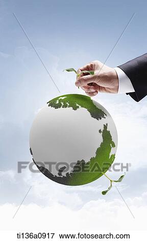 a man grabbing a plant on the globe View Large Photo Image Stock Photo - a man grabbing a plant on the globe. Fotosearch