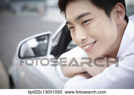 Stock Image - a man in a convertible car. Fotosearch