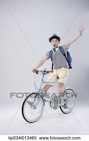 Stock Photography - a man riding a bike waving. Fotosearch