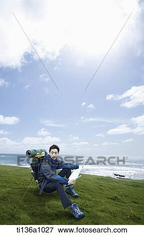 a man sitting on a grass field View Large Photo Image Stock Photo - a man sitting on a grass field. Fotosearch