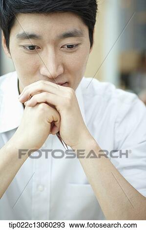 Stock Image - a man with a white shirt thinking. Fotosearch