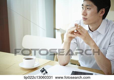 Stock Image - a man with a white shirt thinking. Fotosearch
