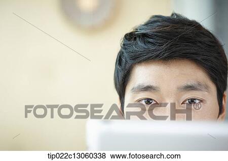 Stock Photo - a man with a white shirt working with a tablet. Fotosearch