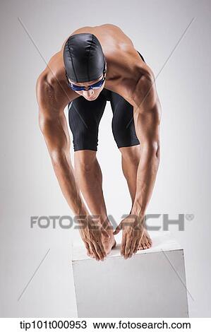 Stock Image - a man with swimming goggle and hat In swimming pose. Fotosearch
