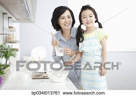 a mother and a daughter cooking together View Large Photo Image Stock Image - a mother and a daughter cooking together. Fotosearch