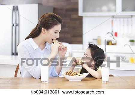 a mother and a daughter enjoying cookies in the kitchen View Large Photo Image Stock Image - a mother and a daughter enjoying cookies in the kitchen. Fotosearch