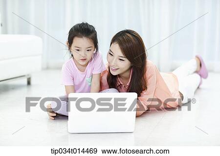 Stock Photo - a mother and daughter using laptop together. Fotosearch