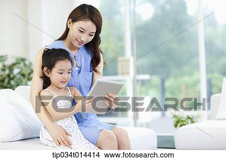 Picture - a mother and daughter using tablet PC together. Fotosearch