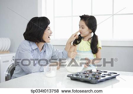 a mother playing with daughter while cooking View Large Photo Image Stock Photo - a mother playing with daughter while cooking. Fotosearch