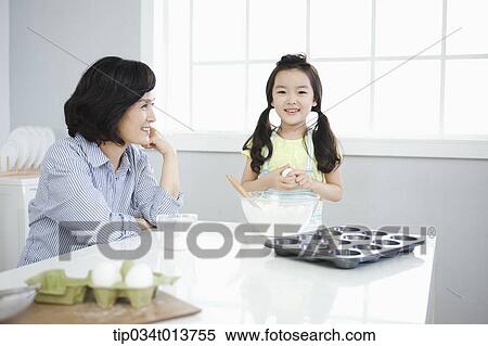 a mother watching daughter cooking View Large Photo Image Stock Photography - a mother watching daughter cooking. Fotosearch