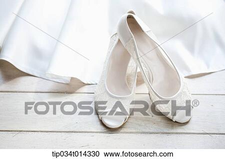 a pair of white heels on tip of wedding dress View Large Photo Image Stock Image - a pair of white heels on tip of wedding dress. Fotosearch