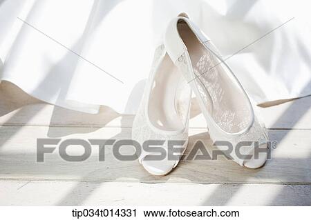 a pair of white heels on tip of wedding dress View Large Photo Image Stock Image - a pair of white heels on tip of wedding dress. Fotosearch