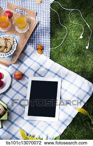 a picnic set and a tablet spread out on a sheet View Large Photo Image Stock Image - a picnic set and a tablet spread out on a sheet. Fotosearch