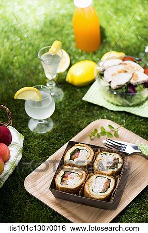 a picnic set spread out on the grass View Large Photo Image Stock Photograph - a picnic set spread out on the grass. Fotosearch