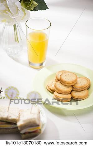 a plate full of cookies next to a glass of juice View Large Photo Image Stock Image - a plate full of cookies next to a glass of juice. Fotosearch