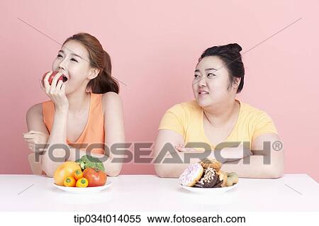 a thin and chubby woman sitting at table with different food in front View Large Photo Image Stock Photography - a thin and chubby woman sitting at table with different food in front. Fotosearch