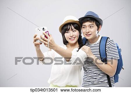 Stock Image - a travelling couple taking a picture together. Fotosearch