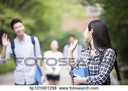 a university student greeting a friend in the campus holding books View Large Photo Image Stock Photo - a university student greeting a friend in the campus holding books. Fotosearch