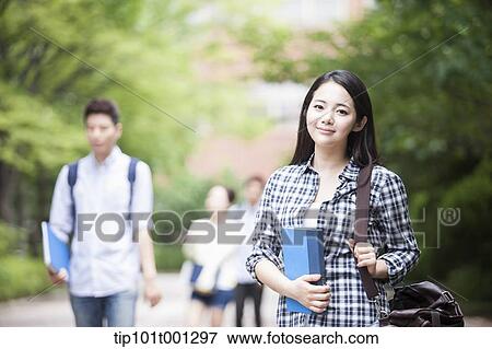 a university student standing in the campus holding books View Large Photo Image Stock Photo - a university student standing in the campus holding books. Fotosearch