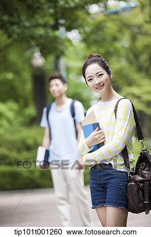 a university student walking in the campus holding books View Large Photo Image Stock Image - a university student walking in the campus holding books. Fotosearch