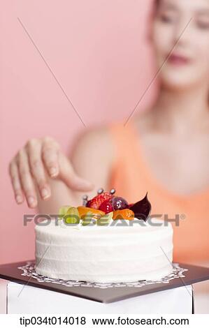 a woman about to grab a cake in front of her View Large Photo Image Stock Photo - a woman about to grab a cake in front of her. Fotosearch