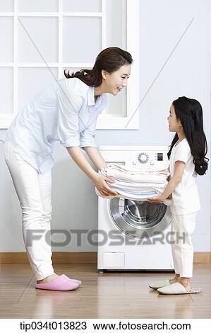 Stock Image - a woman and a daughter with folded towers. Fotosearch
