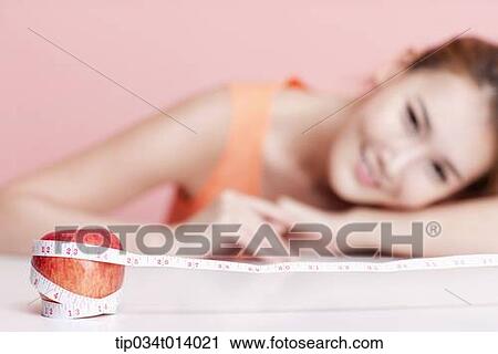 a woman and an apple wrapped with measurement tape View Large Photo Image Stock Image - a woman and an apple wrapped with measurement tape. Fotosearch
