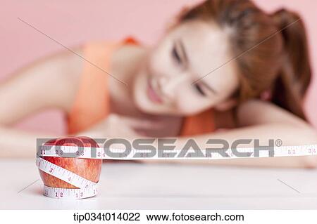 a woman and an apple wrapped with measurement tape View Large Photo Image Stock Image - a woman and an apple wrapped with measurement tape. Fotosearch