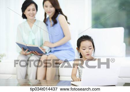 Stock Photo - a woman and daughter watching kid using laptop. Fotosearch
