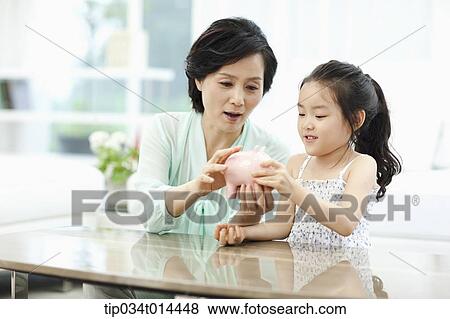 a woman and grand daughter with a piggy bank View Large Photo Image Stock Photo - a woman and grand daughter with a piggy bank. Fotosearch