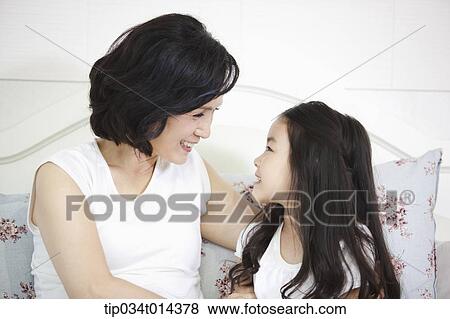 Stock Photo - a woman and granddaughter looking at each other. Fotosearch