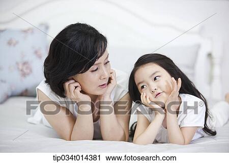 a woman and granddaughter lying on a bed View Large Photo Image Stock Image - a woman and granddaughter lying on a bed. Fotosearch