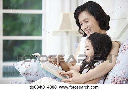 a woman and granddaughter reading a book together View Large Photo Image Stock Image - a woman and granddaughter reading a book together. Fotosearch